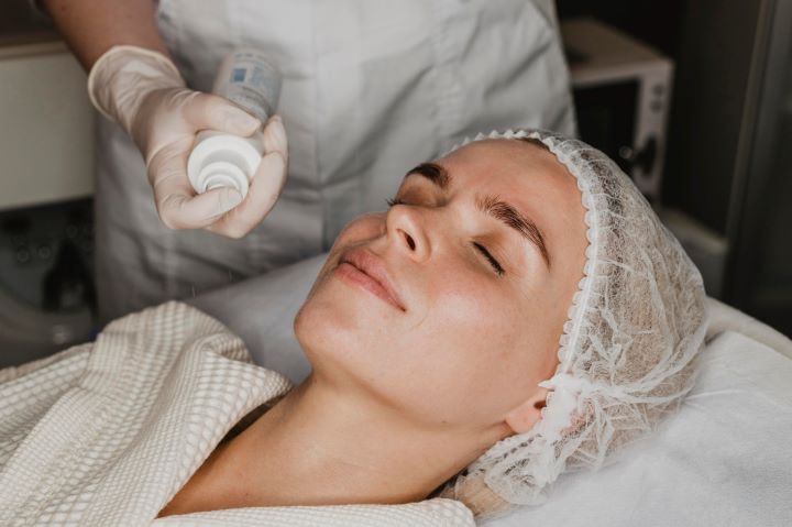 young woman getting face skin treatment spa