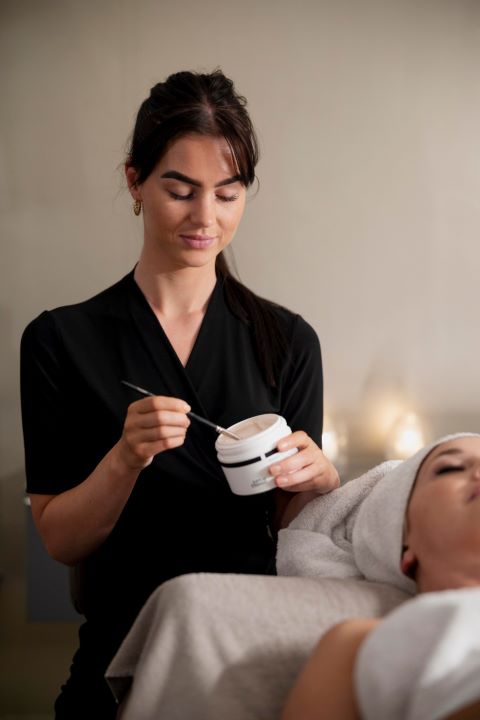 young woman using face treatment her client